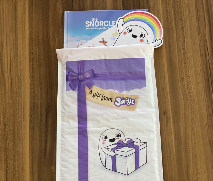 Image contains a photo of a children's book, stickers, and an envelope.