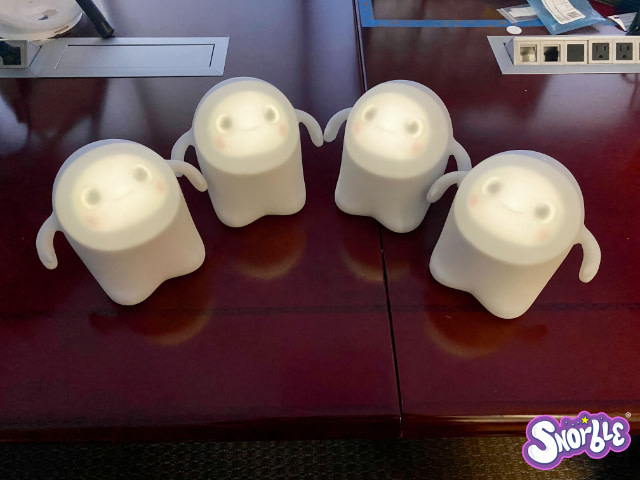 Image contains a photo of four Snorbles looking at the camera. They are sitting on a wooden table and the Snorble logo is in the bottom right-hand corner.