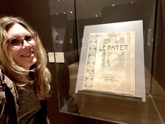 Cat posing with an original publication of Alphonse Mucha's Le Pater. 