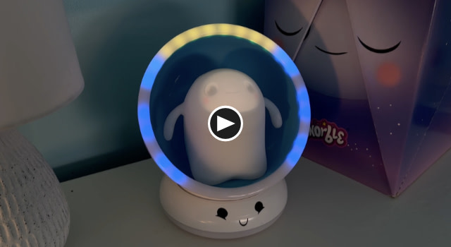 Image contains a photo of Snorble® in their Lullapod™ with blue and yellow lights shining around the edge. In the middle of the photo, there is a play button.