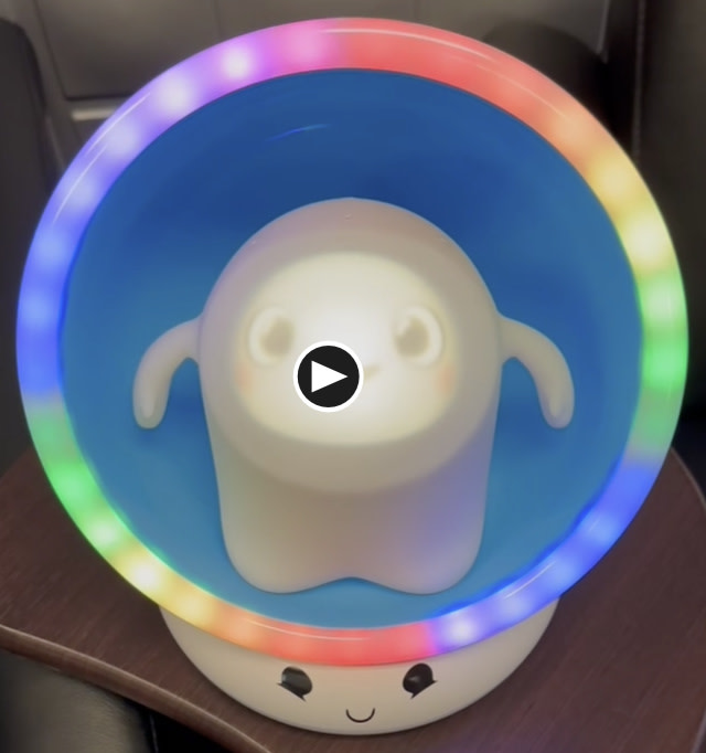 Image contains a photo of Snorble® sitting in the LullaPod with rainbow lights around them.