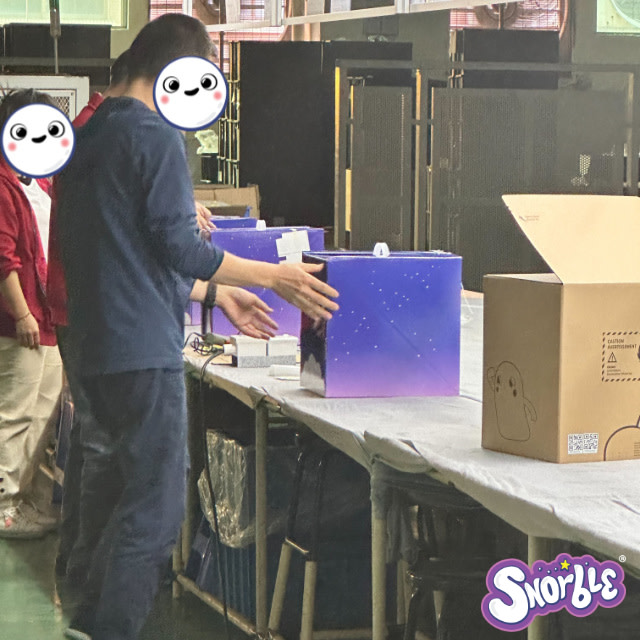 Factory workers prepare shipping boxes for Snorble®.
