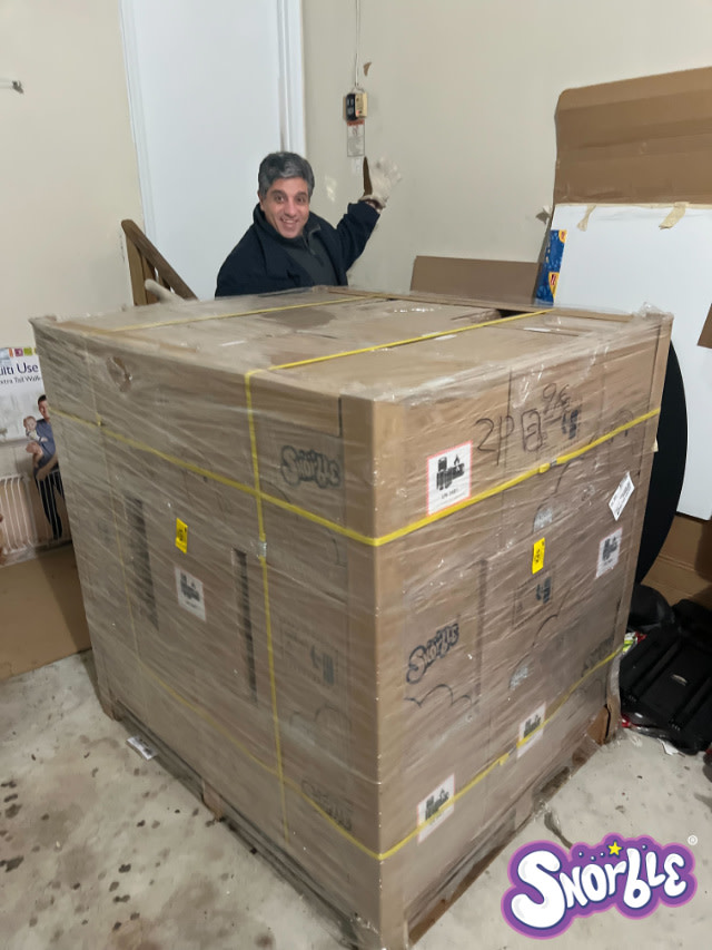 Image contains Snorble® CEO, Mike Rizkalla, with a pallet of Snorbles® after their arrival.