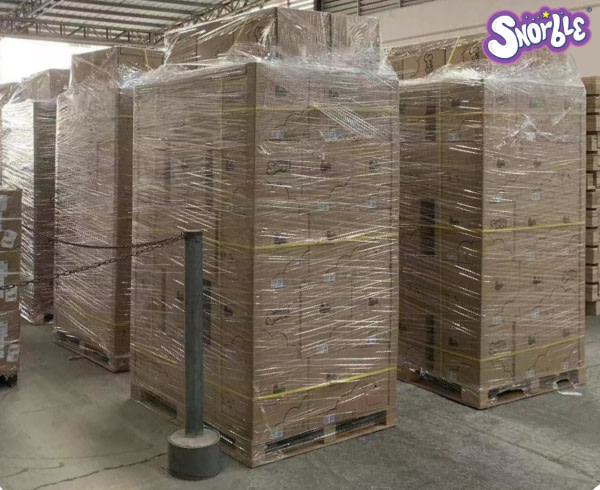 Image contains a photo of a number of pallets of Snorble® prepared for shipping in a factory.