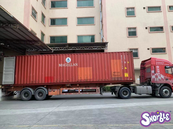 Image contains a photo of a container truck at a factory waiting for loading.