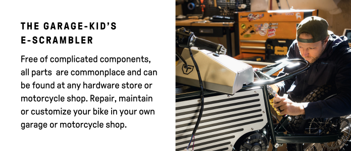 In a workshop full of tools, someone works on Terra Bikes E-Scrambler, a sleek electric motorcycle designed for DIY maintenance with easily accessible parts for hands-on enthusiasts.